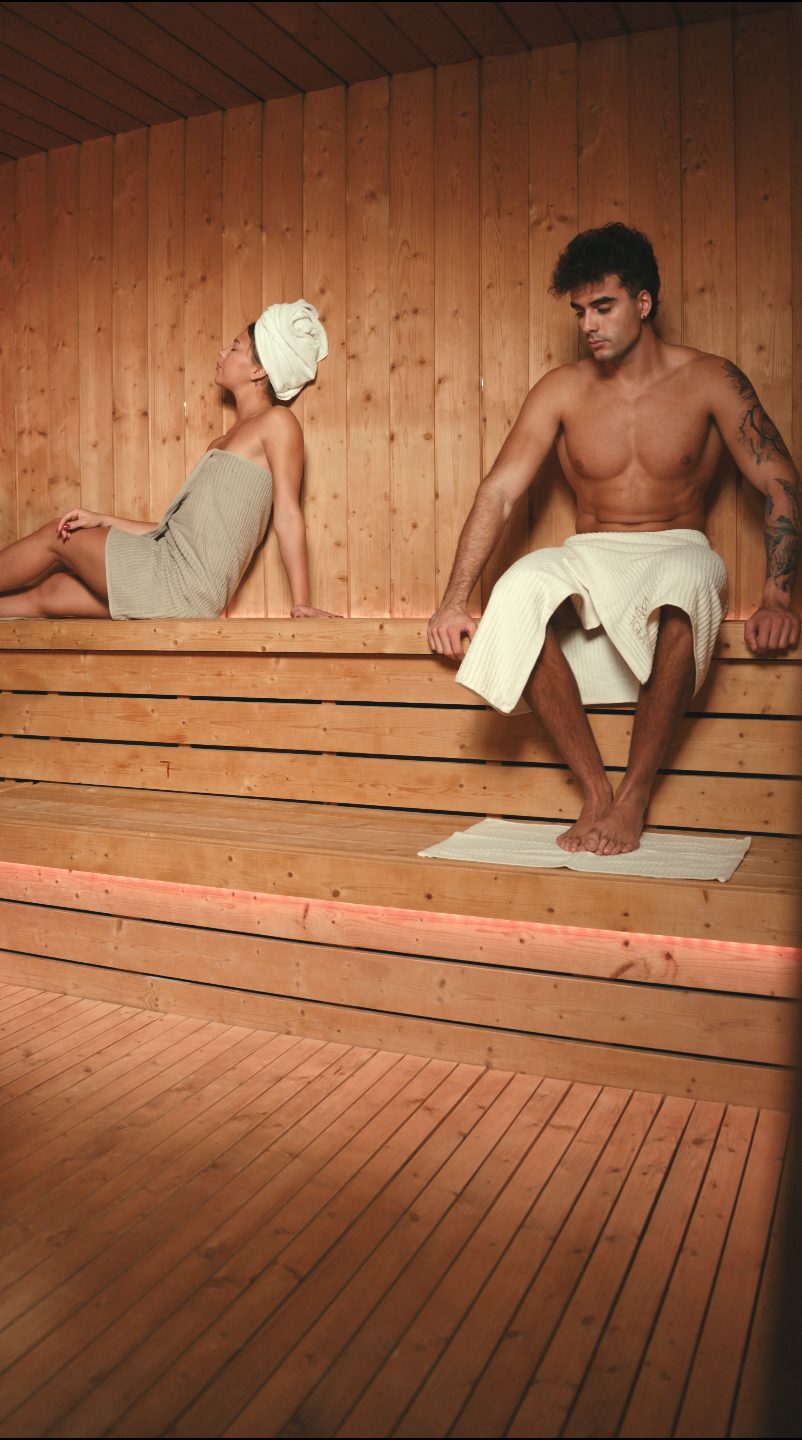 Due ospiti seduti sulle panche della sauna